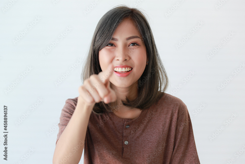 Studio portrait shot of Asian happy young beautiful pretty confident female teenager teen model in casual wears smiling laughing show teeth look at camera pointing index finger on white background Studio portrait shot of Asian happy young beautiful pretty confident female teenager teen model in casual wears smiling laughing show teeth look at camera pointing index finger on white background