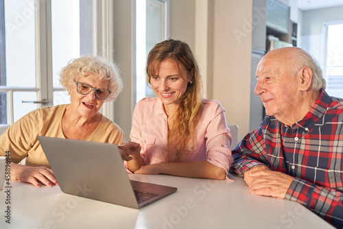 Tochter hilft Senioren Eltern mit Laptop Computer photo