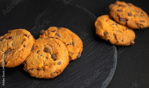 Fresh crispy chocolate cookies on a dark table