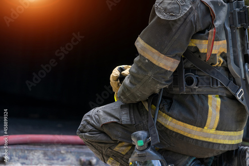 Fireman wearing firefighter turnouts holding helmet ready for emergency service,Fireman in emergency situation.