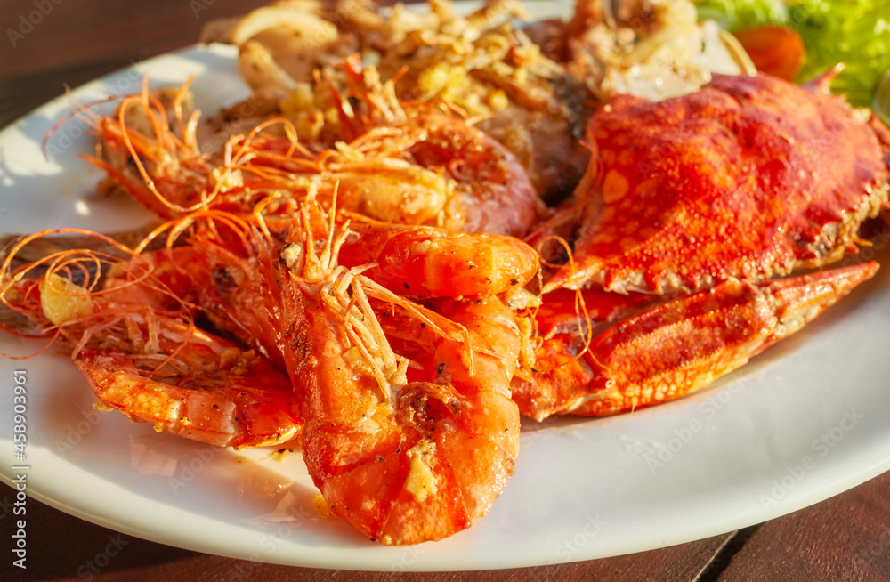Grilled seafood platter with crab and prawns with garlic, selective focus. Grilled seafood platter with crab and prawns with garlic, selective focus.