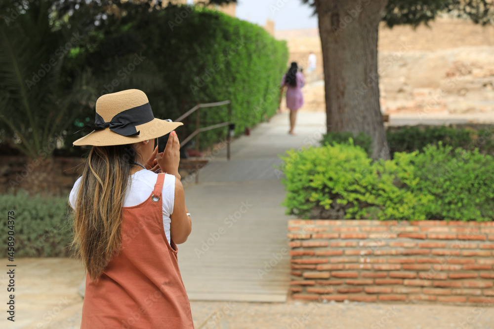 mujer rubia con sombrero en el parque sacando fotografias con el móvil 4M0A5333-as21