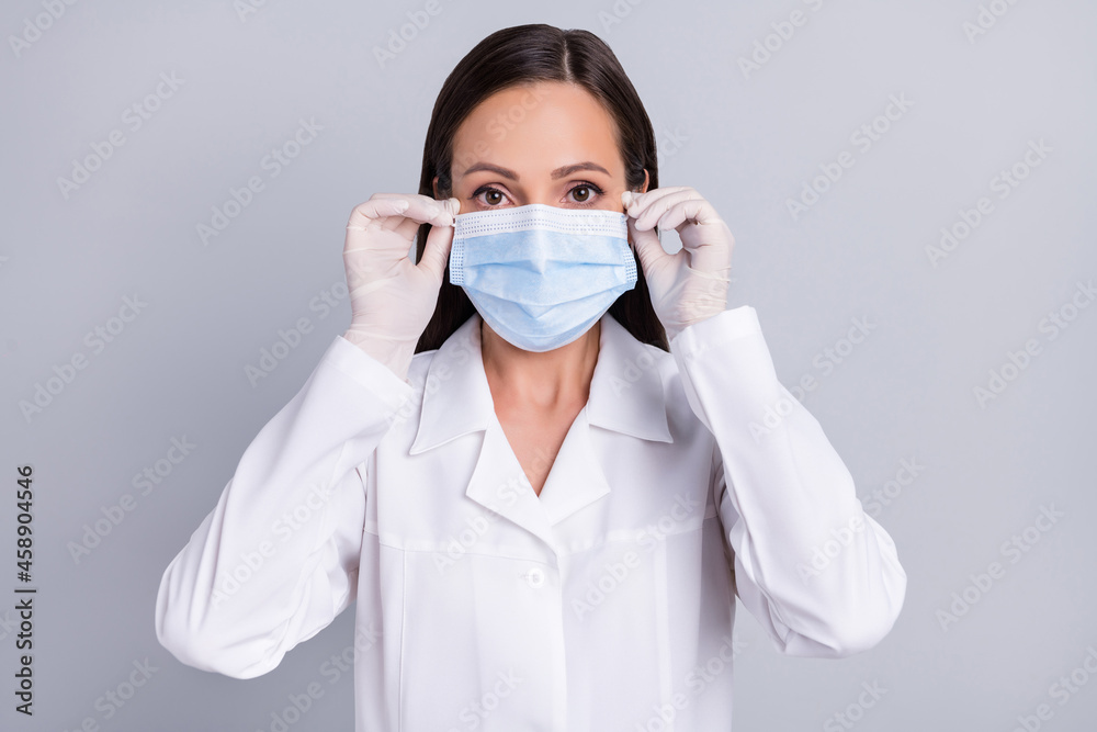 Portrait of attractive skilled doctor wearing mask stop mers cov flu isolated over grey pastel color background Portrait of attractive skilled doctor wearing mask stop mers cov flu isolated over grey pastel color background