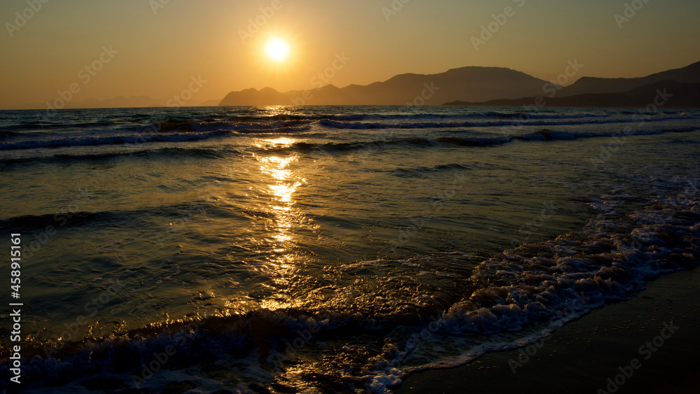 Fototapeta premium Spawning place of Caretta Caretta turtles: Iztuzu beach. Golden sun rays reflecting off the sea at sunset. Spectacular sunset at the meeting point of the Mediterranean and Aegean.