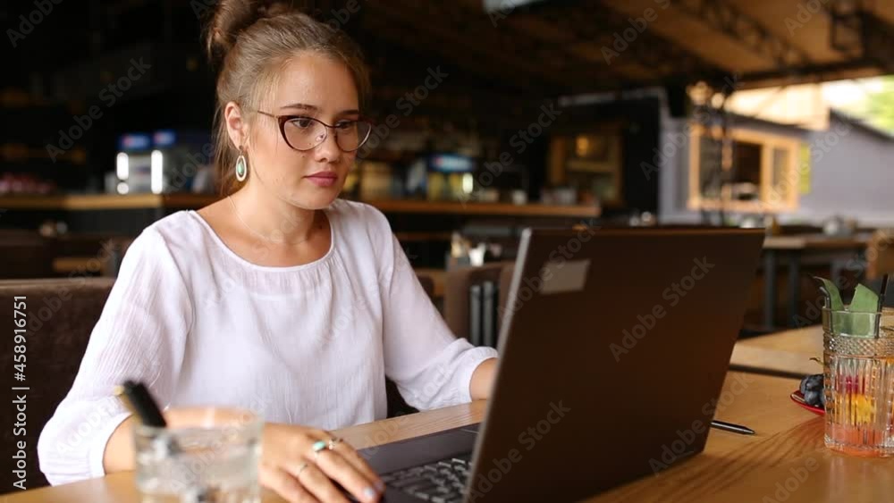 Freelancer woman opens her laptop, facial recognition system gets face detection scanning to access the computer. Infrared camera scans female face. Biometry in electronics. Female starts work in cafe Freelancer woman opens her laptop, facial recognition system gets face detection scanning to access the computer. Infrared camera scans female face. Biometry in electronics. Female starts work in cafe