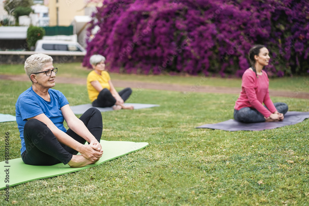 Happy people doing yoga class at city park - Focus on right senior face Happy people doing yoga class at city park - Focus on right senior face