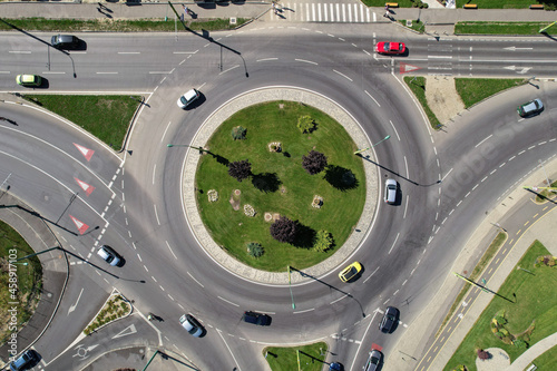 Top down aerial view of a busy street traffic circle roundabout on a main road in an urban area photo