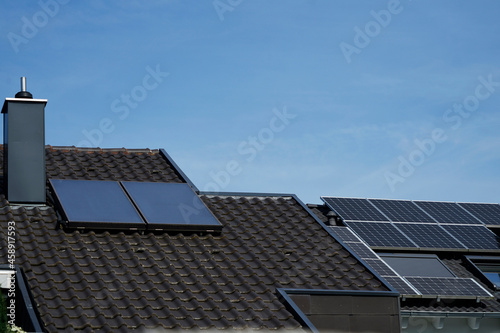 Solarthermie- und Photovoltaik Panele auf zwei Hausdächern..Ein Sinnbild für Solarenergie und bewusstes Leben.