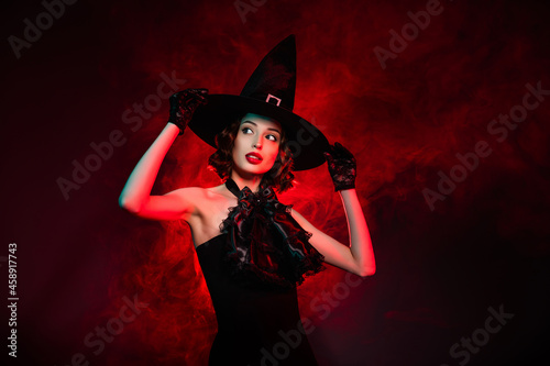 Photo of seductive creepy mystic lady wear black dress arms hands gothic headwear looking empty space isolated dark red smoke color background