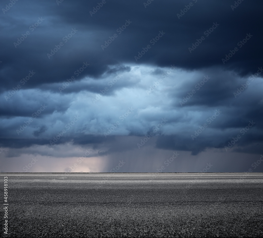 Storm clouds above asphalt road, side view