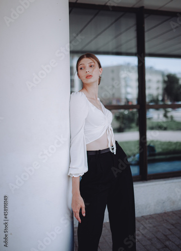 a beautiful girl in a white shirt walks around the city, a model girl in the city