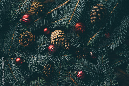 Christmas tree branches and festive decoration on wooden background.