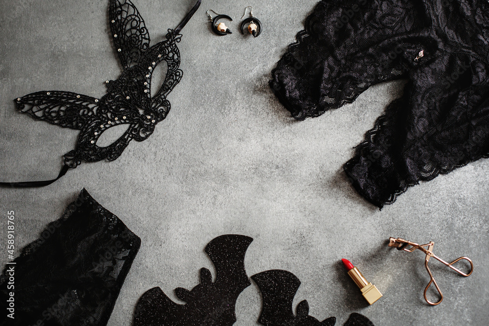 Flat lay composition with black sexy lace face mask and lingerie for Halloween party on grey background, top view from above - obrazy, fototapety, plakaty 