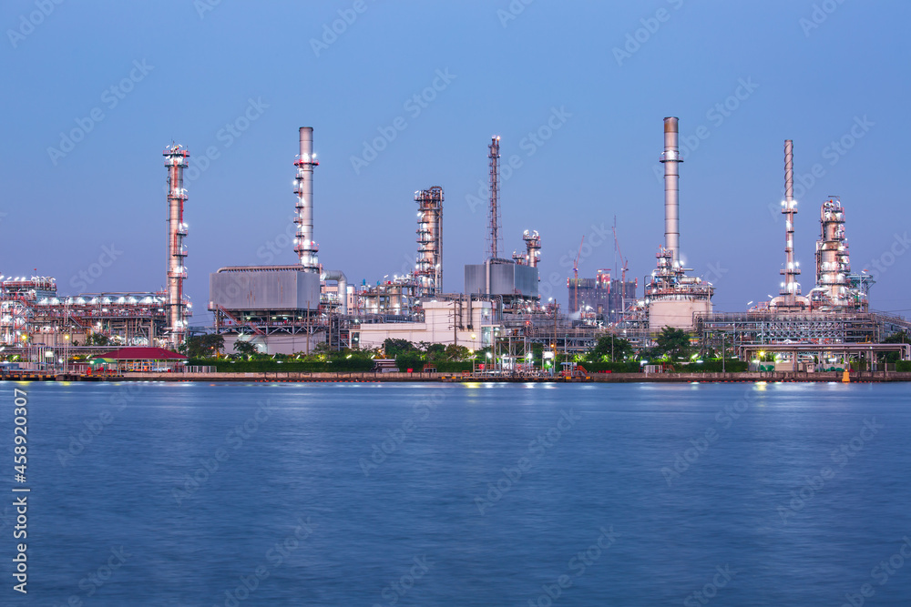 Twilight scene of oil refinery plant of Petrochemistry  front water reflection.