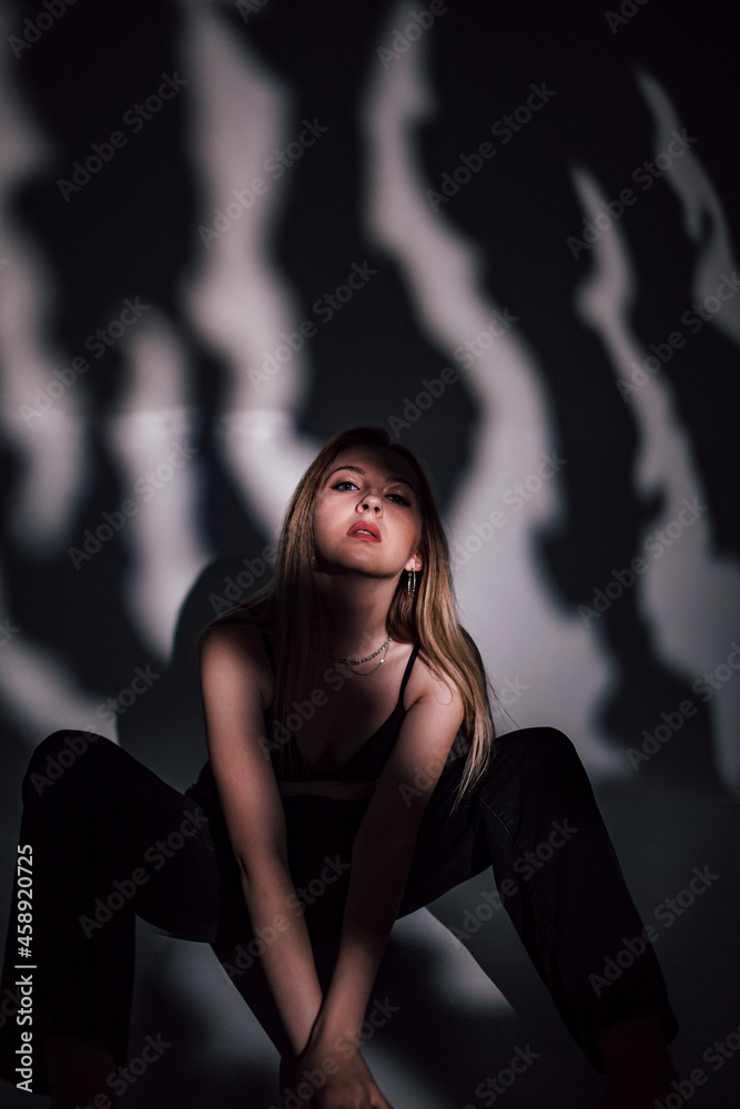 beautiful girl in a black bodice in the studio, chiaroscuro on her face