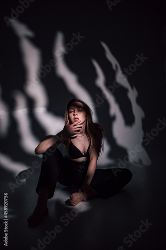 beautiful girl in a black bodice in the studio  chiaroscuro on her face