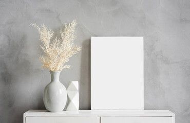 Blank canvas frame mockup on gray wall. White living room design. View of modern scandinavian style interior with artwork mock up on wall. Home staging and minimalism concept