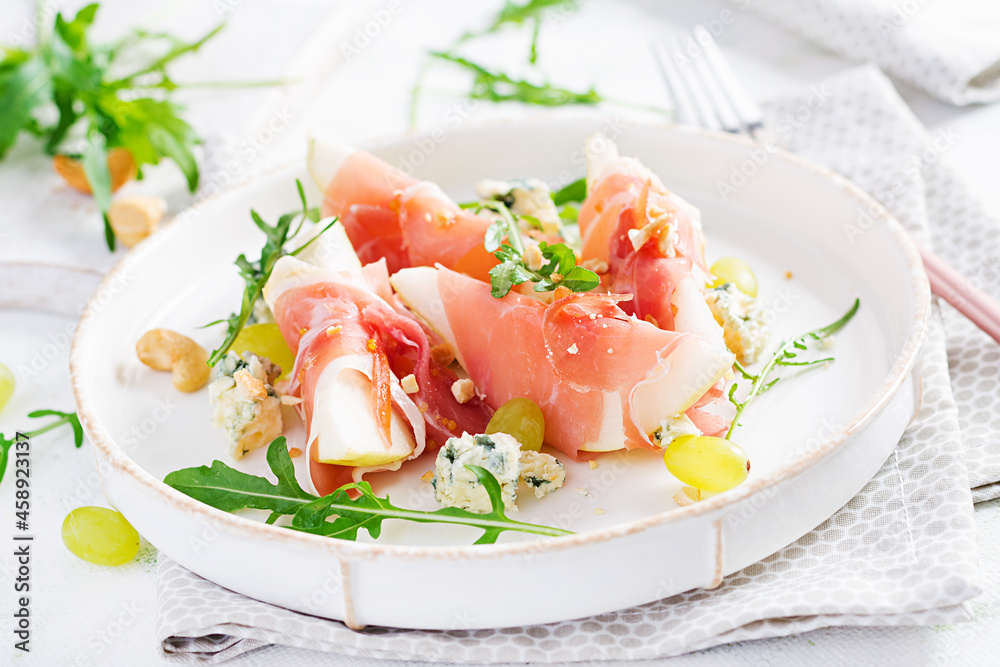 Appetizer with pear, blue cheese and prosciutto ham for holidays on a white plate. Appetizer with pear, blue cheese and prosciutto ham for holidays on a white plate.