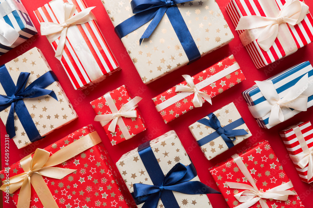 Fototapeta premium A lot of Christmas gift boxes in colored paper decorated on table, Top view close up. Many present New Year gift