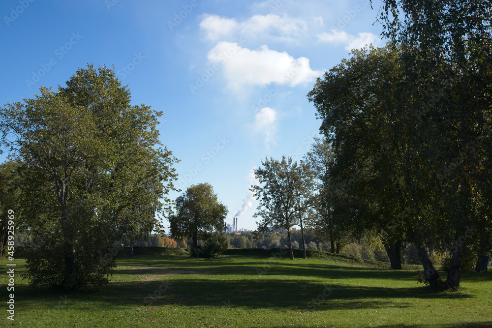 city park trees and distant fuming factory chimneys, Lappeenranta Finland