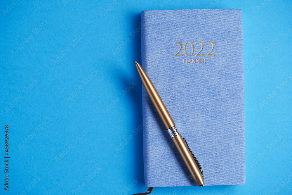 2022 diary and pen on blue background