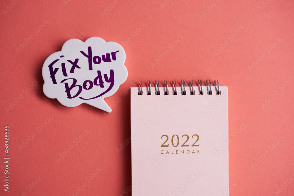 calendar 2022 with speech bubble written fix your body on orange background calendar 2022 with speech bubble written fix your body on orange background
