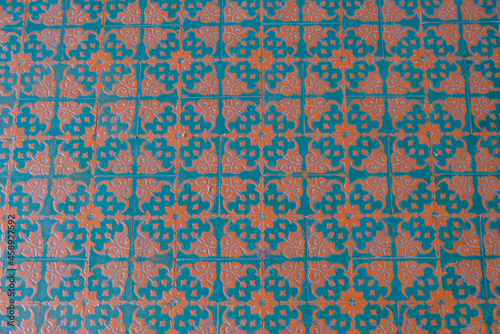 Blue and orange pattern on floor tiles close-up. Top view. Interior design. Tiles background