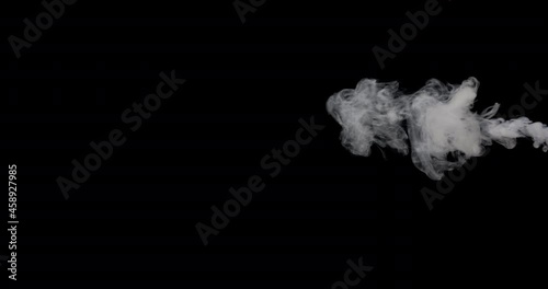 Smoke slowly rising to the top against a black background. photo