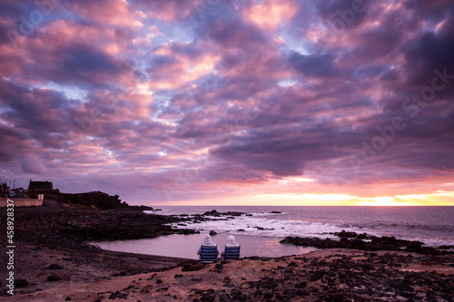 Sunset landscape at the beach with sea ocean and waves in background - dramatic sky with sun and clouds - dusk light and horizon