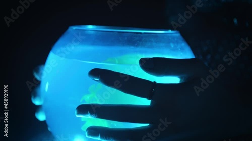 A girl holds a glowing aquarium