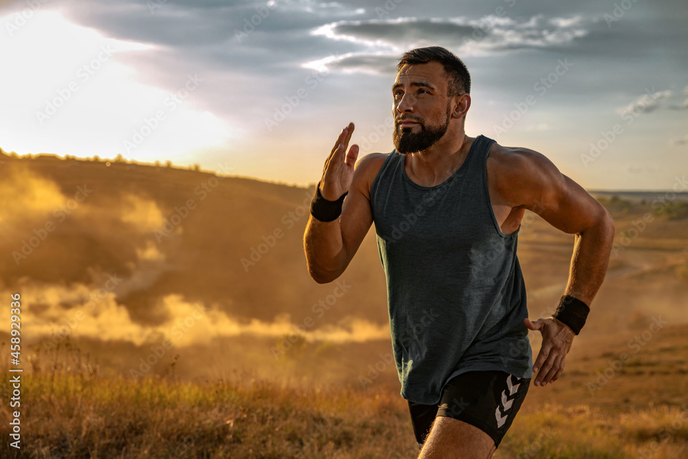 Runner concept. Athletic man running trail on sunset wearing in the  sportswear. Fitness and sport motivation. Athlete sprinter run. Stock Photo