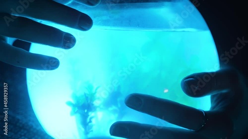 A girl holds a glowing aquarium