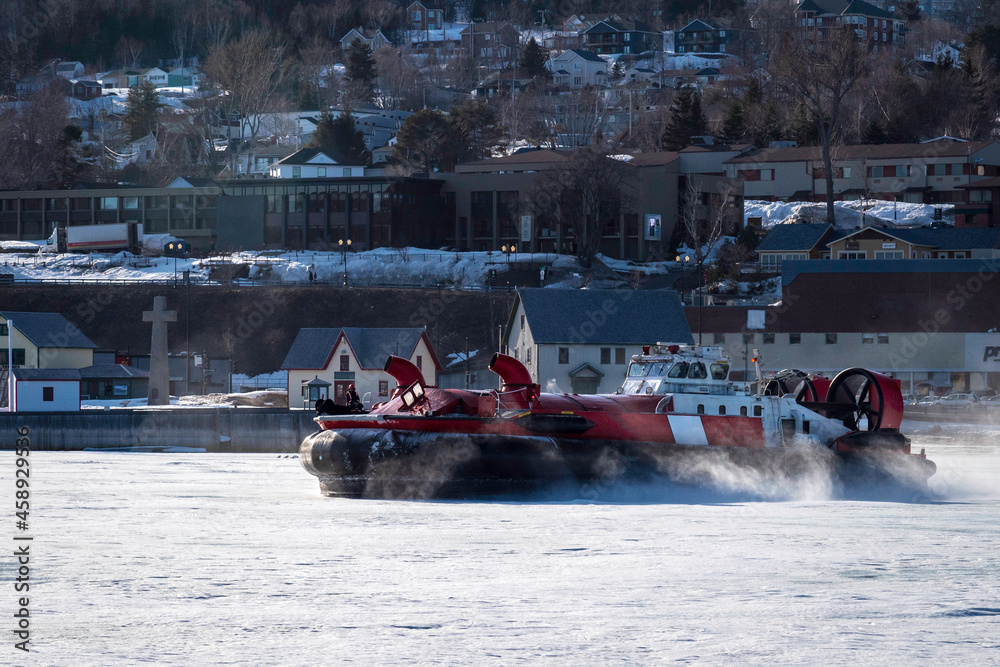 Fototapeta premium Coast Guard hovercraft breaking ice near a small community in eastern Quebec, Canada.