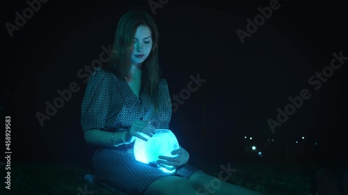 A girl holds a glowing aquarium