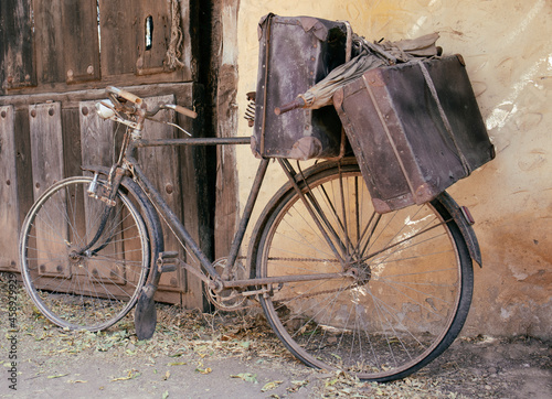 Fotografija old and broken bicycle, abandoned on a facade