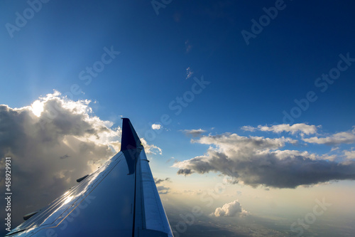 View of the airplane wing during a beautiful colorful cloudy sunset