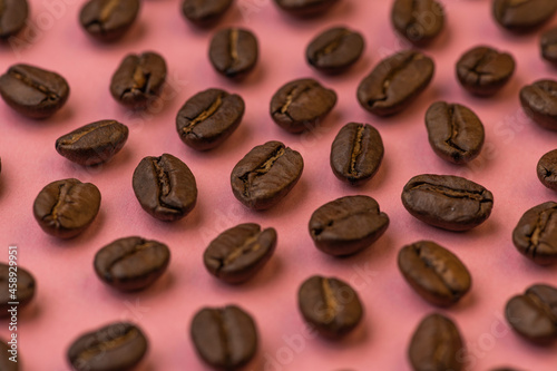 Coffee beans close up on a pink background
