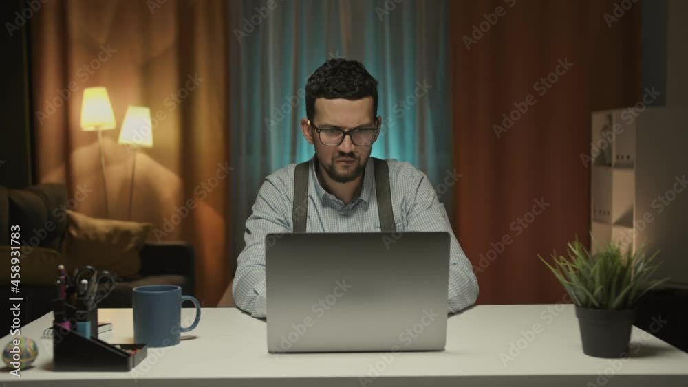 Handsome Arab Man Works on a Personal Computer, Points at Screen and Shows Thumbs Up. In the Background Cozy Living Room. In Slow Motion. Handsome Arab Man Works on a Personal Computer, Points at Screen and Shows Thumbs Up. In the Background Cozy Living Room. In Slow Motion.