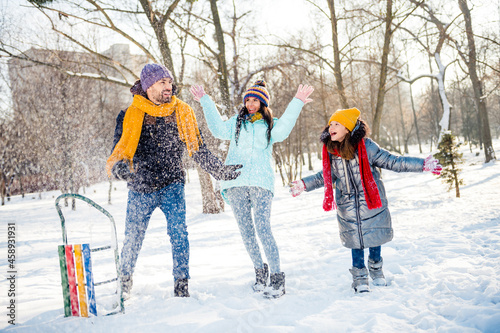 Full size photo of happy excited good mood funky family enjoying winter holiday outdoors throwing snow having fun photo