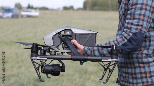 Man pilot checking quadcopter drone before aerial flight and filming