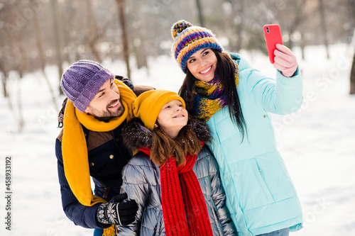 Photo of lovely family mom dad daughter happy positive smile make selfie cellphone vacation winter trip outdoors