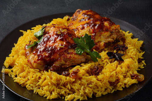The national Saudi Arabian dish chicken kabsa with roasted chicken quarter and almonds, raisins, garlic and biryani rice
