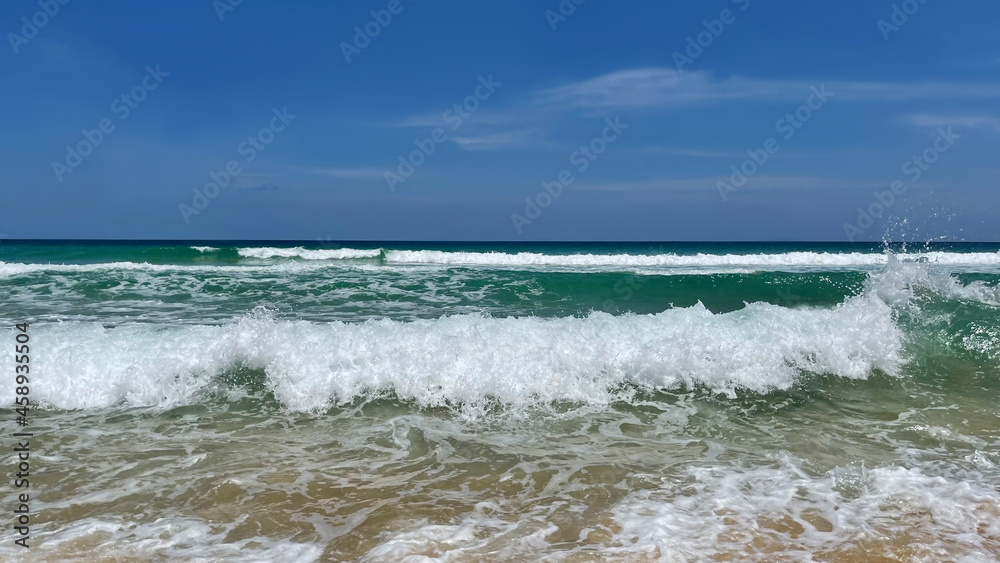 Panorama. Sea view. Waves with white foam. Turquoise water. Skyline, horizon. Blue sky with clouds. Sand beach, sandy shore. Coastline. Closeup, macro. Background. Ocean, expanse of water. Tropical.