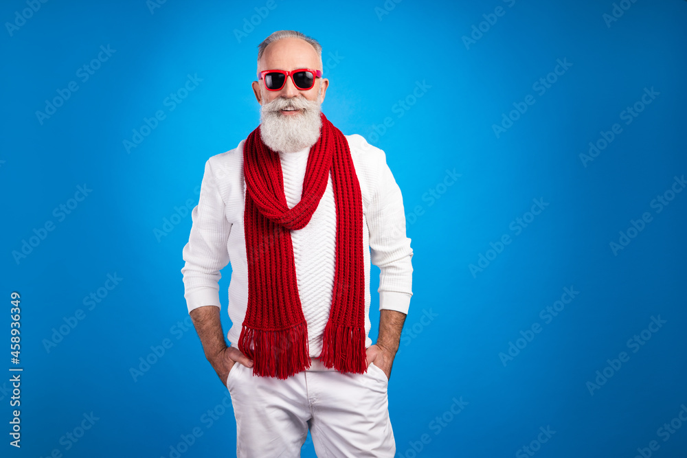 Photo of sweet confident mature man dressed white pullover red glasses arms pocket smiling empty space isolated blue color background