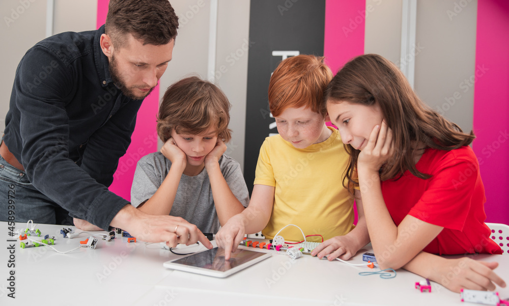 Teacher and kids during robotics lesson Teacher and kids during robotics lesson