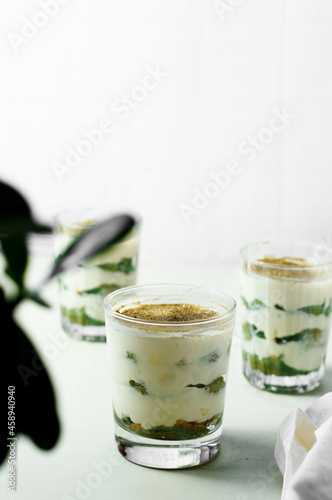 Matcha green tea tiramisù in a glass. White background