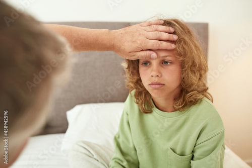 Parent take care on sick unhealthy son having fever
