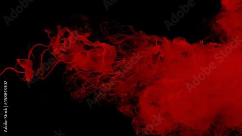 Drops of red ink in water. Cosmic star background. Red watercolor paints in water on a black background. Beautiful wallpaper for your desktop. Red cloud of ink.
