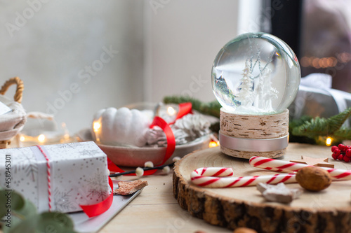 Christmas decorations, a snow globe and presents and star shaped biscuits.