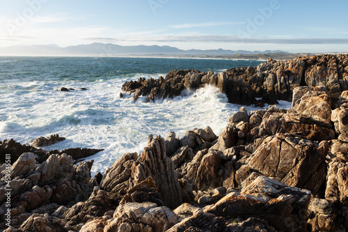 Jagged rocks on the Atlantic ocean coastline and white water waves breaking. photo